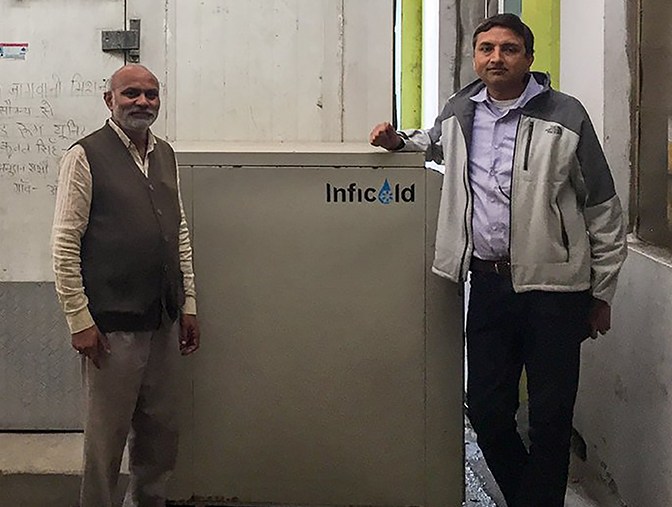 Two Indian men either side of Inficold fridge
