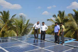 four Indian men with lots of solar panels