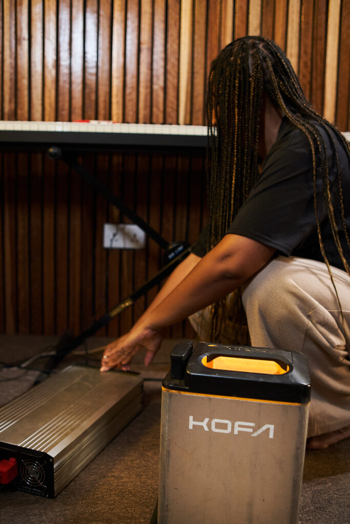 Woman plugging in a battery in a music studio