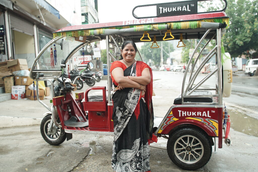 Woman standing proudly with her electric rickshaw