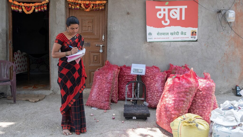 Woman recording weight of food sacks