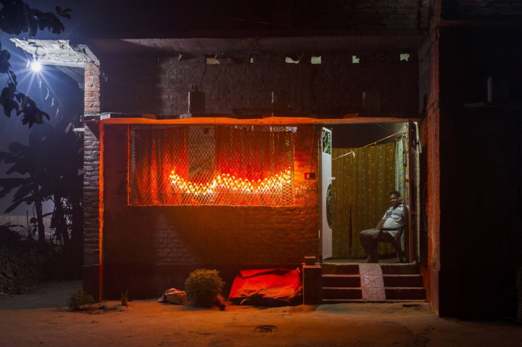 Line of orange lights in shop front at night in India