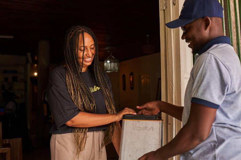 Technician handing over a battery to a women 